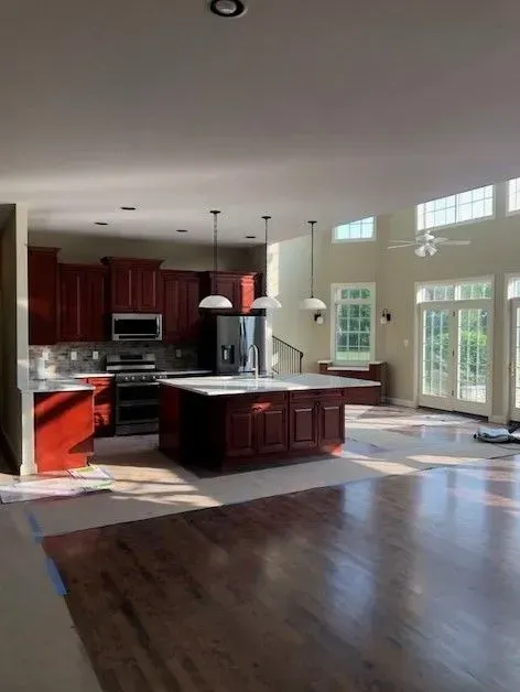 A kitchen with red cabinets and stainless steel appliances