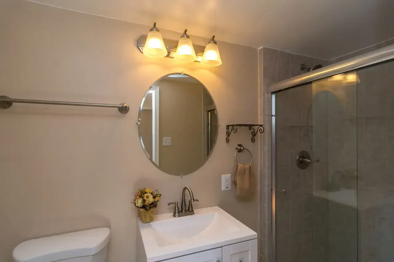 A bathroom with a toilet a sink and a mirror