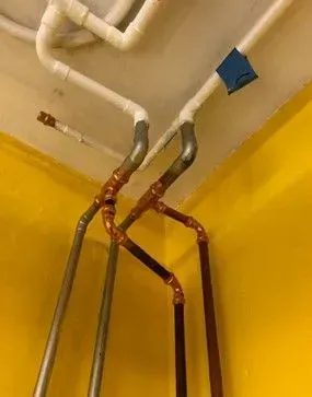 A bunch of pipes are hanging from the ceiling in a room.