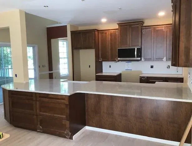 A kitchen with brown cabinets and white counter tops