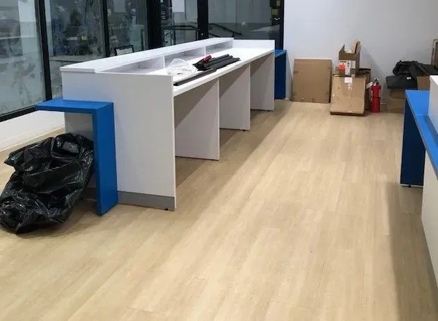 A room with a wooden floor and a long desk.