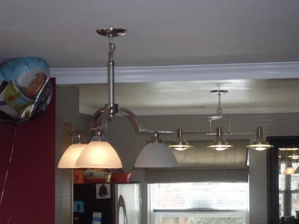 A balloon is hanging from the ceiling next to a light fixture