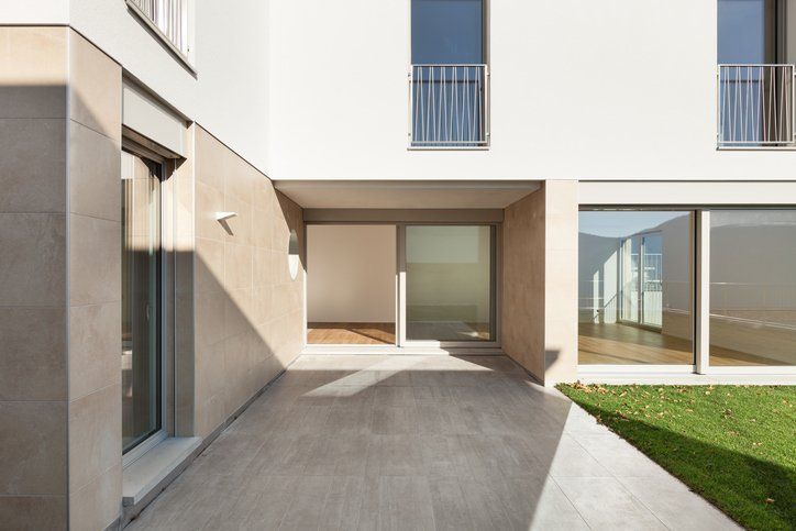 A white building with a concrete walkway leading to it