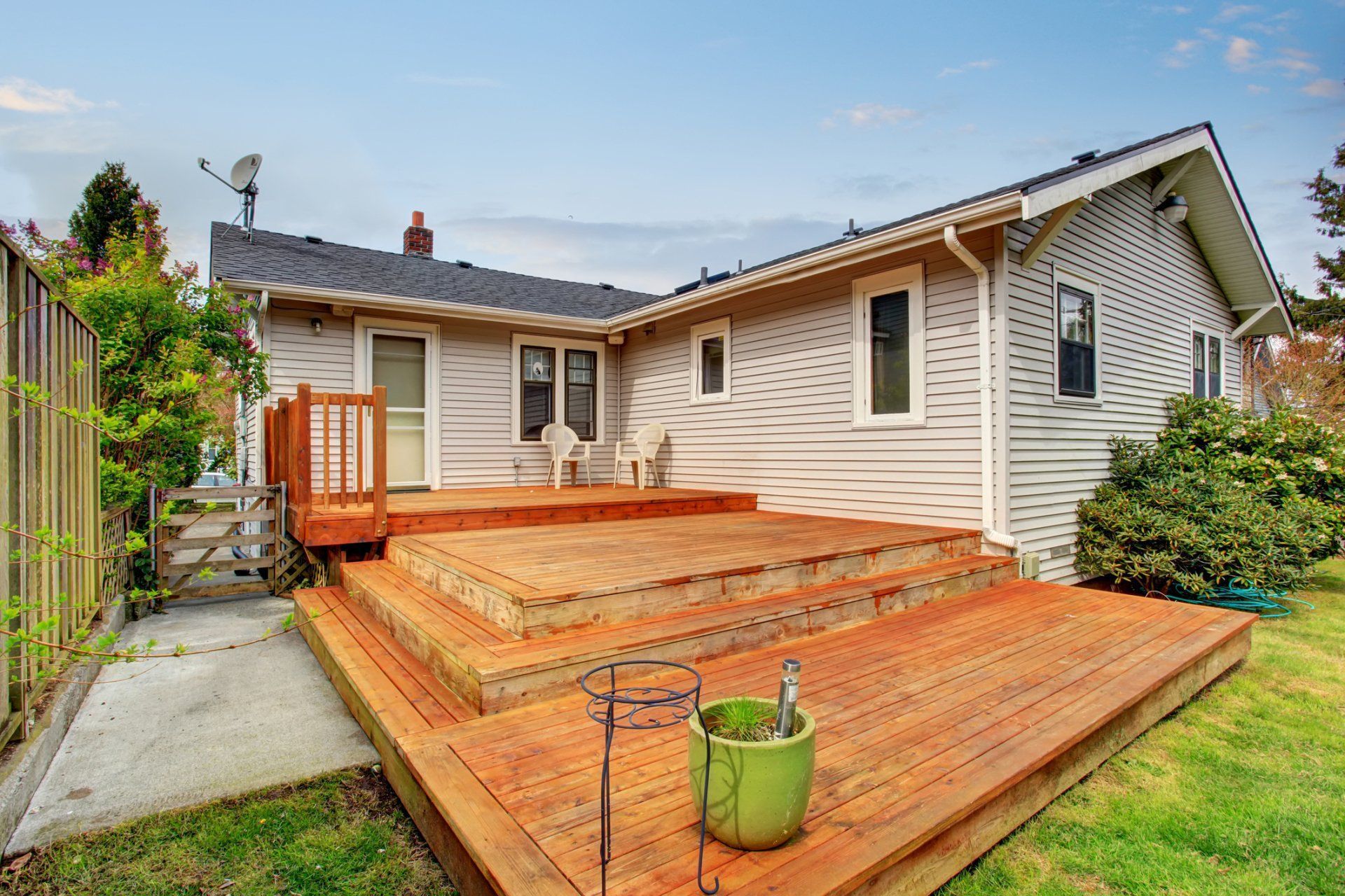 A house with a wooden deck and stairs in front of it.