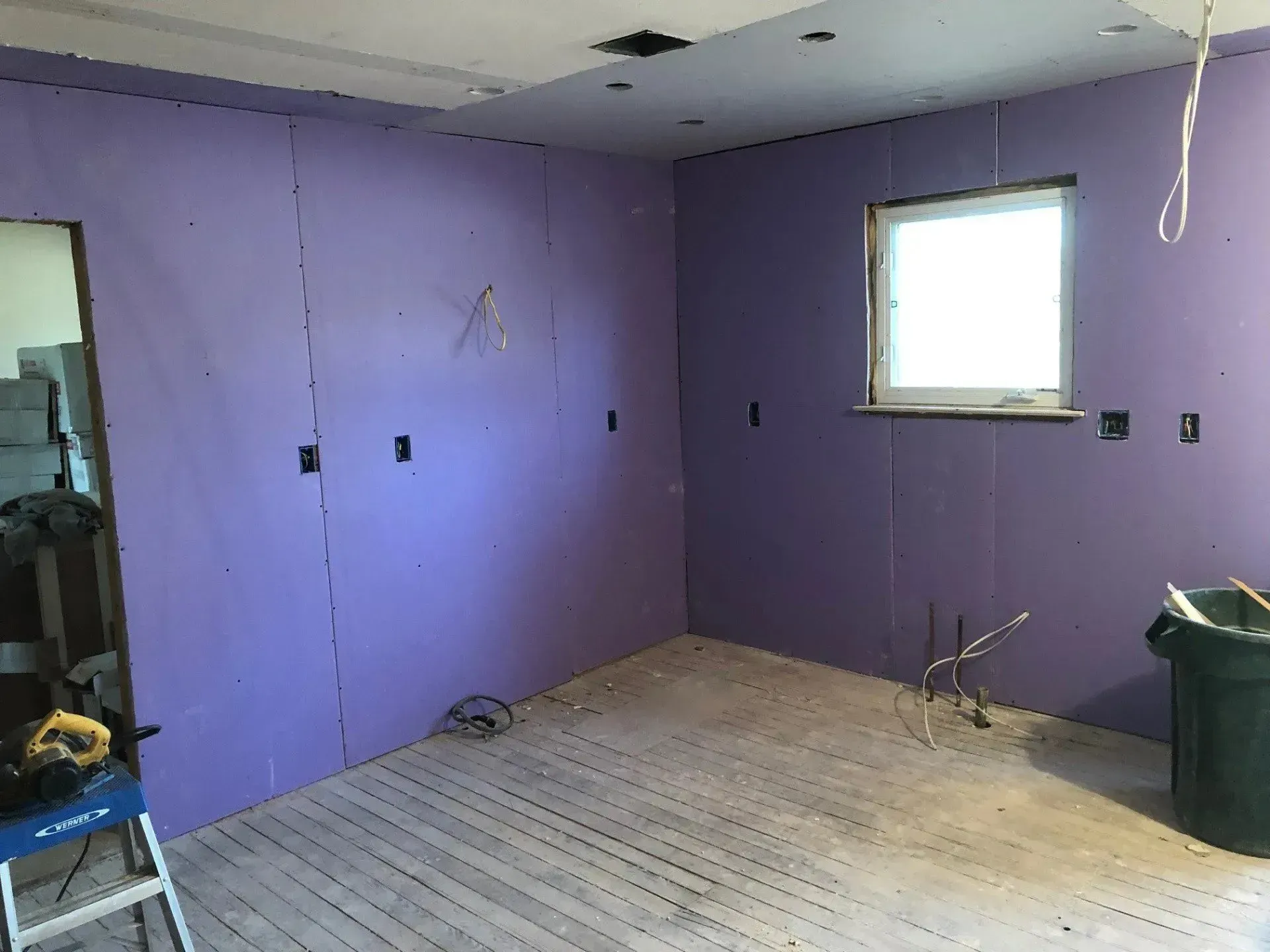 A room with purple walls and a window.