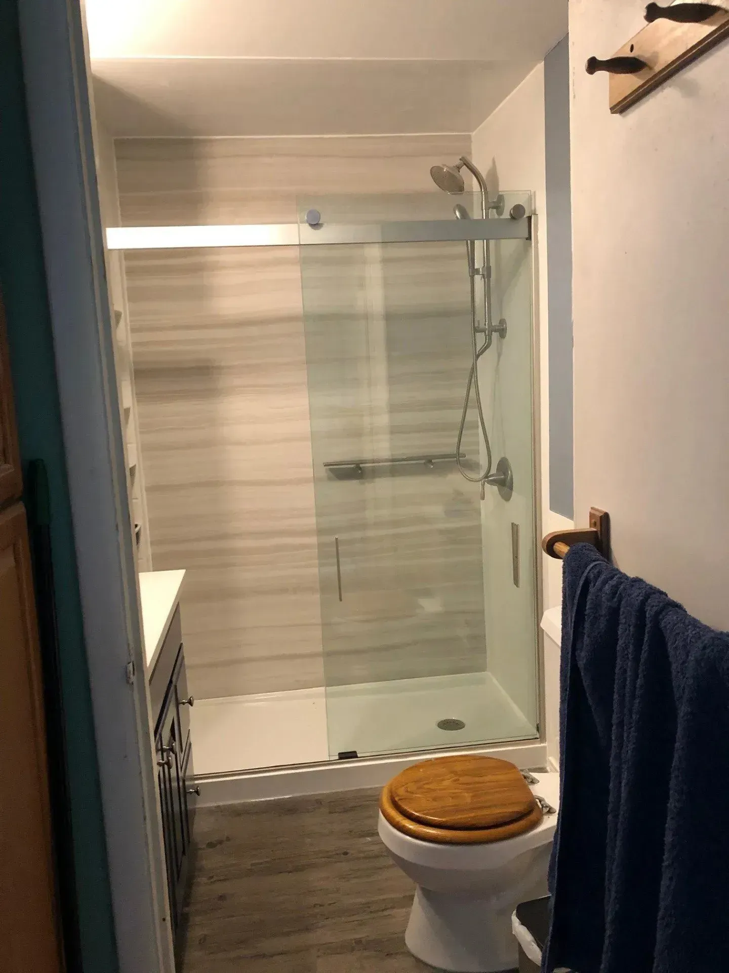 A bathroom with a toilet and a shower with a sliding glass door.