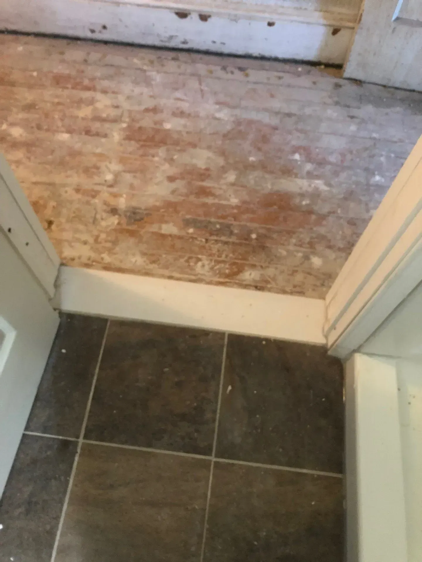 A doorway with a tiled floor and a wooden floor