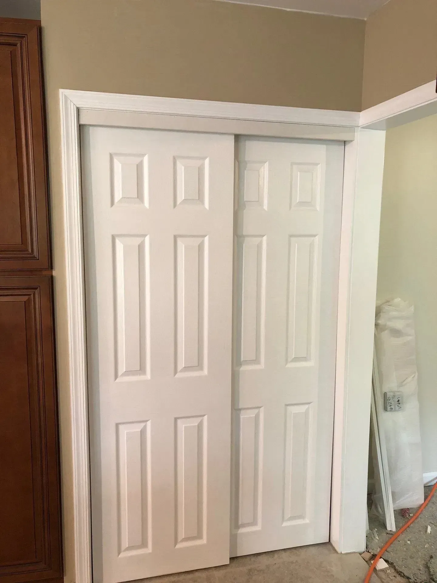 A pair of white sliding doors in a closet.