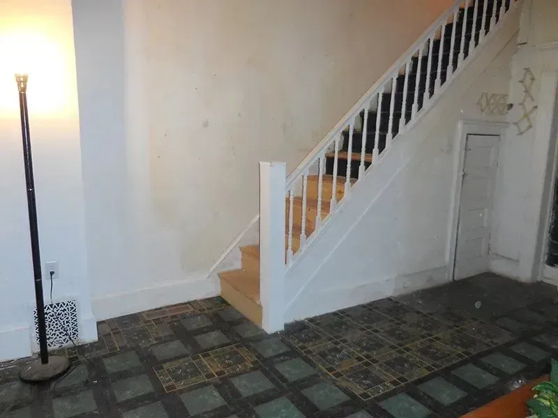 A white staircase with a black railing in a hallway