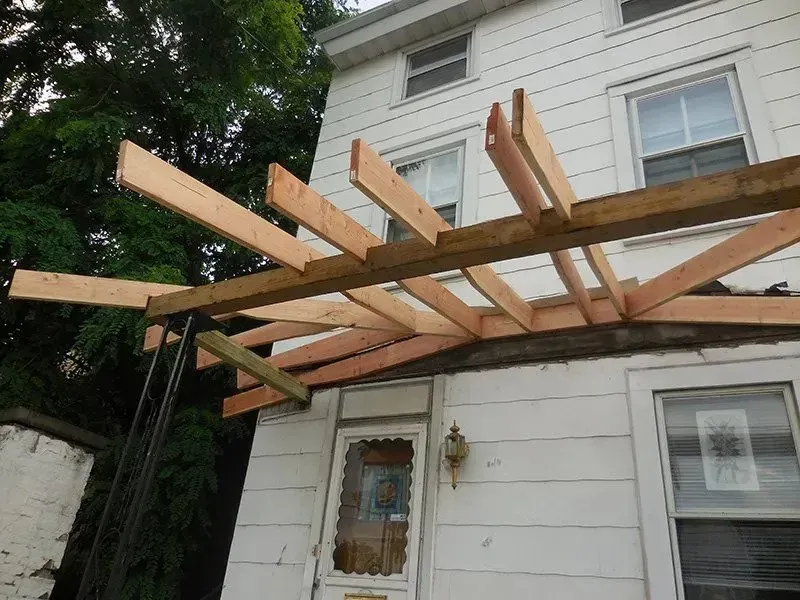 A wooden structure is being built on the side of a house