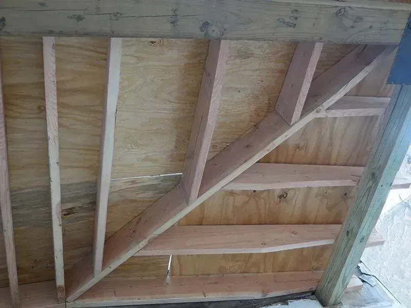 A wooden staircase is being built into a wall.