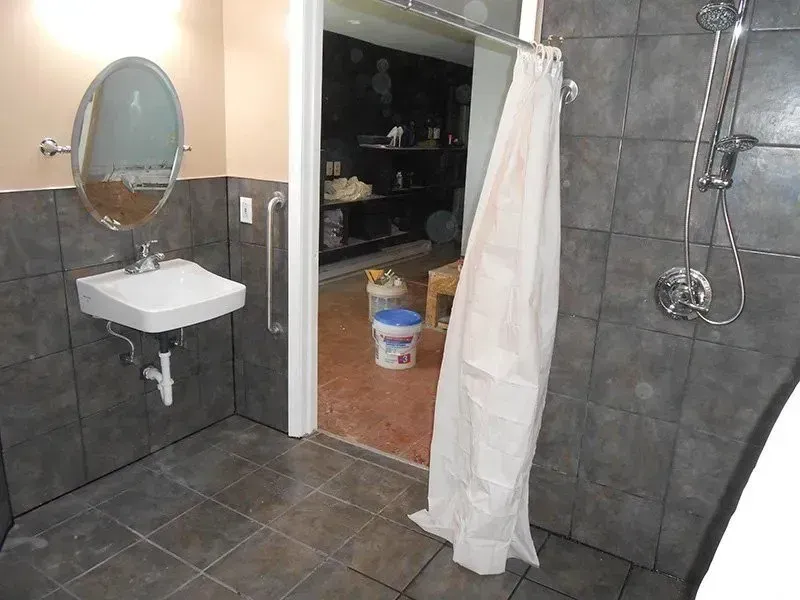 A bathroom with a sink , shower and mirror