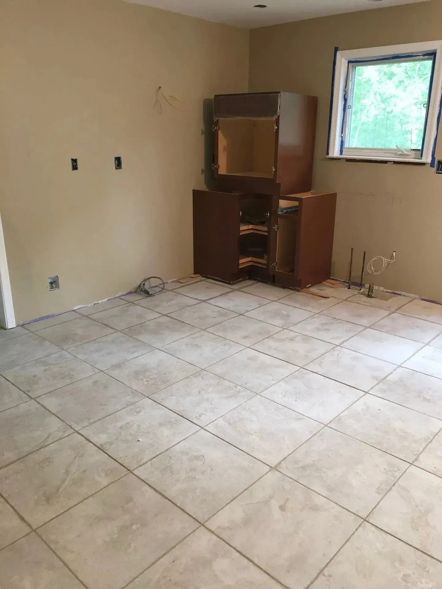 An empty room with a tiled floor and a window.