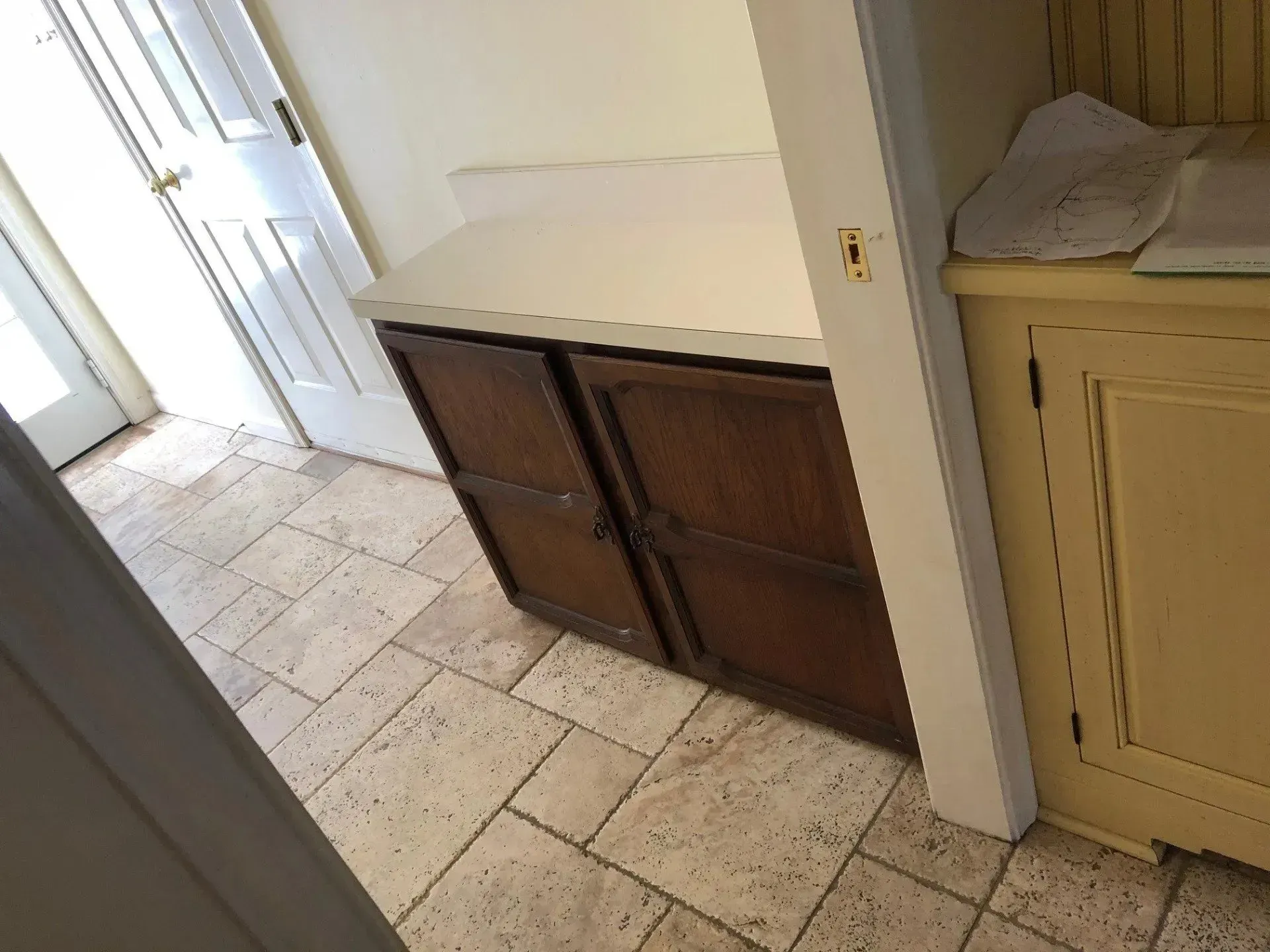 A kitchen with wooden cabinets and a tiled floor