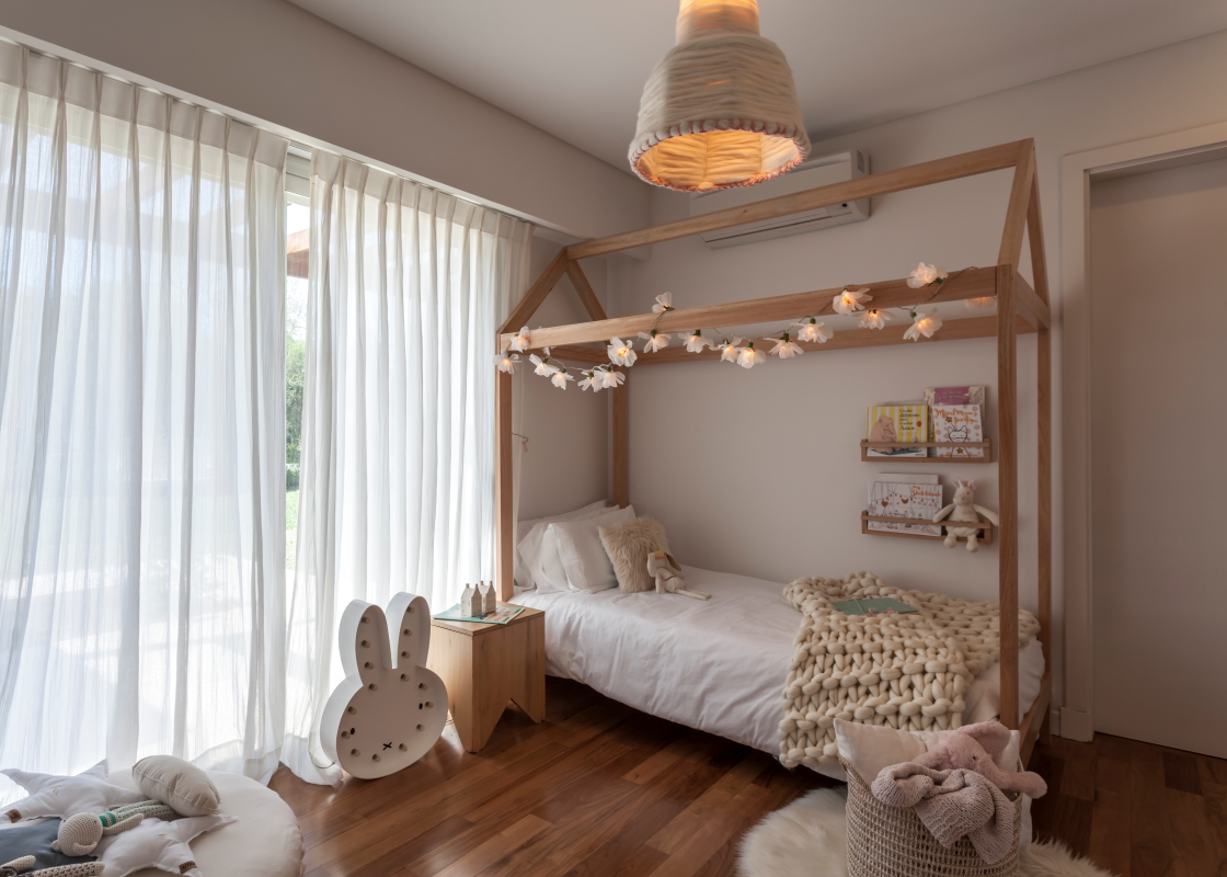 Un dormitorio con una cama, mesita de noche y ventana.