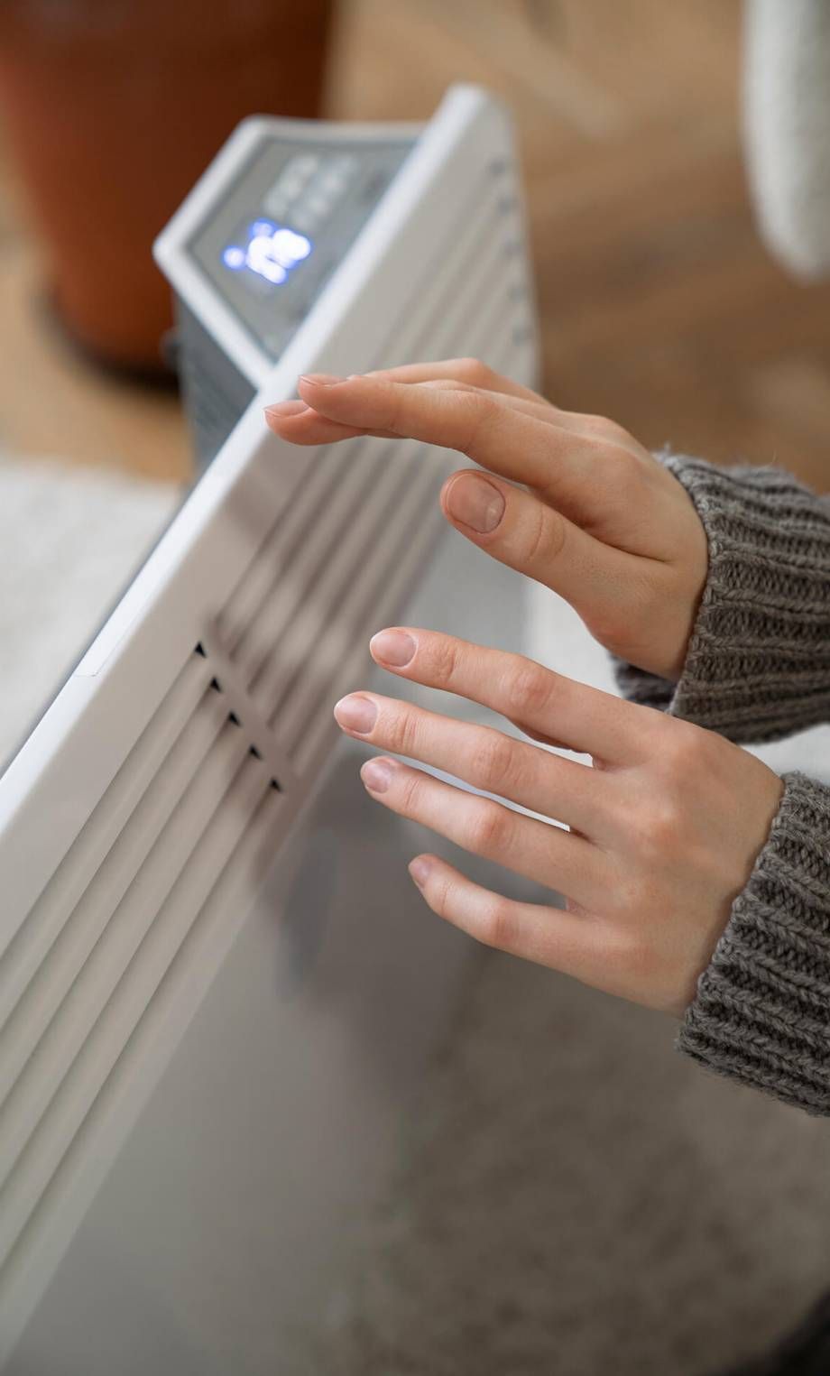 A person is touching a heater with their finger.