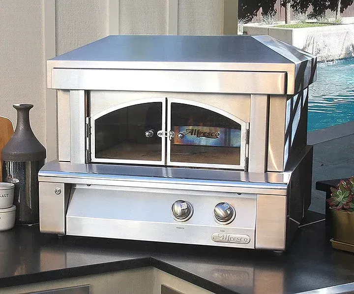 A stainless steel oven is built into a stone wall
