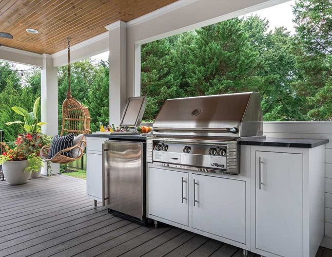 A stainless steel grill is sitting on top of a wooden deck.