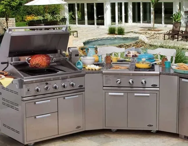 A stainless steel outdoor kitchen with a grill and a sink