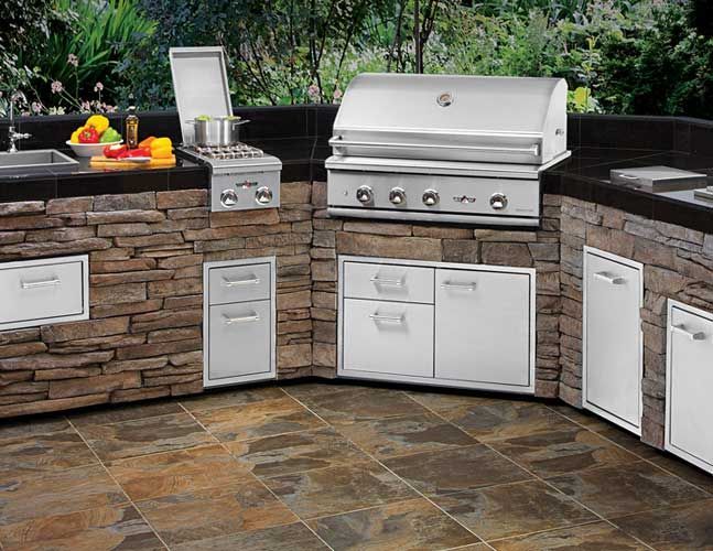An outdoor kitchen with a grill and a sink