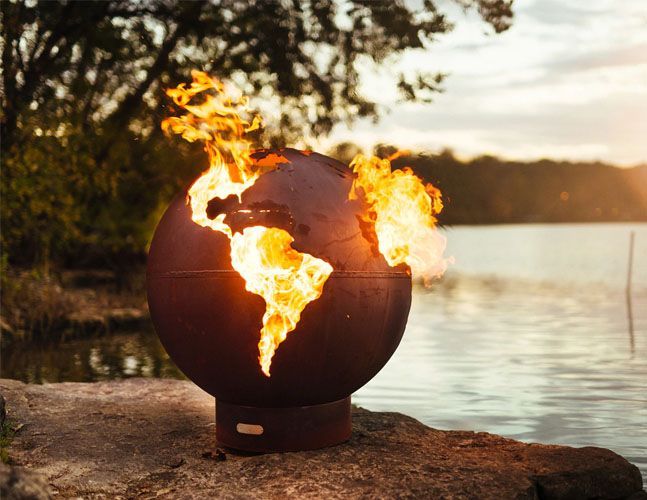 A fire pit in the shape of a globe with flames coming out of it.