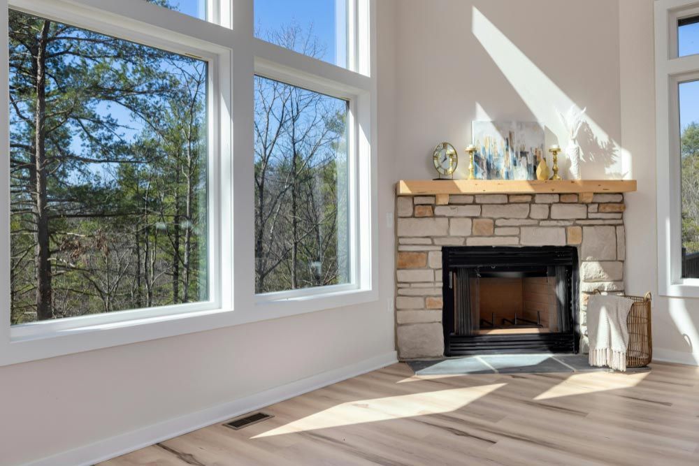A living room with a fireplace and lots of windows.