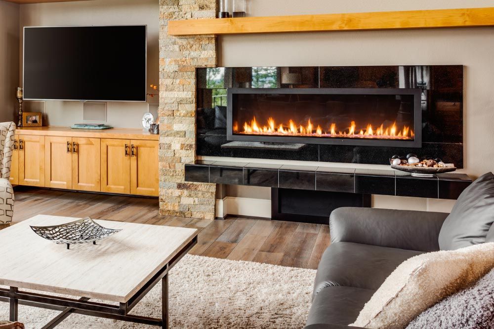 A living room with a fireplace , couch , coffee table and television.