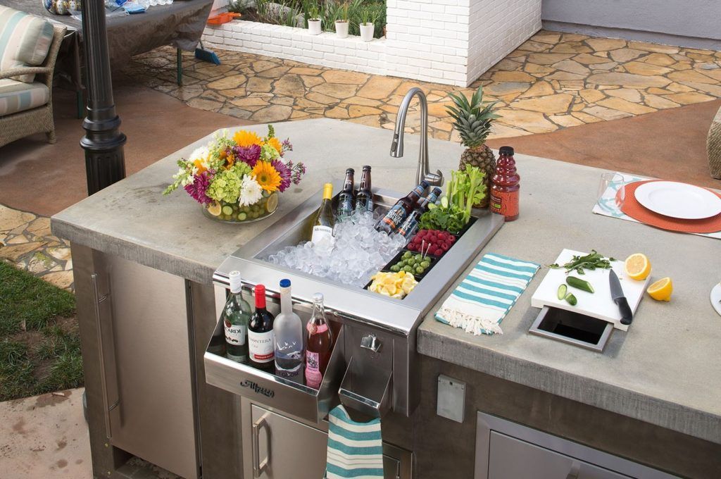 A kitchen counter with a sink and a bowl of flowers on it.