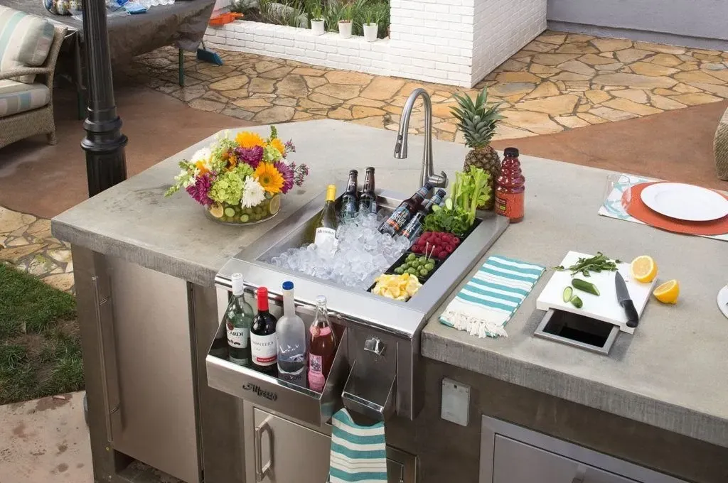 A kitchen counter with a sink and a bowl of flowers on it.