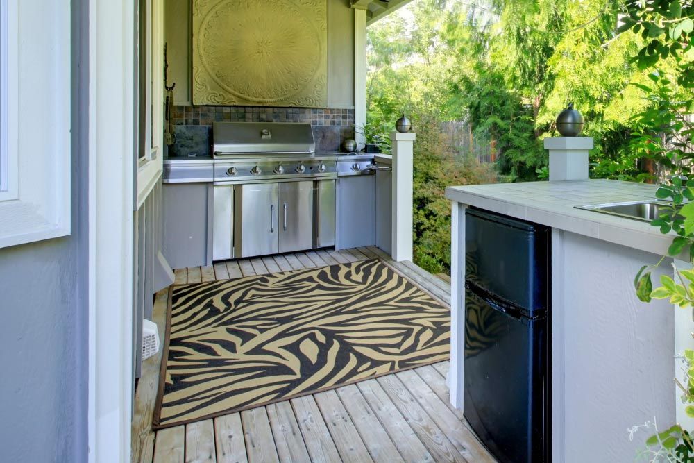 A kitchen with a rug on the floor and a refrigerator.