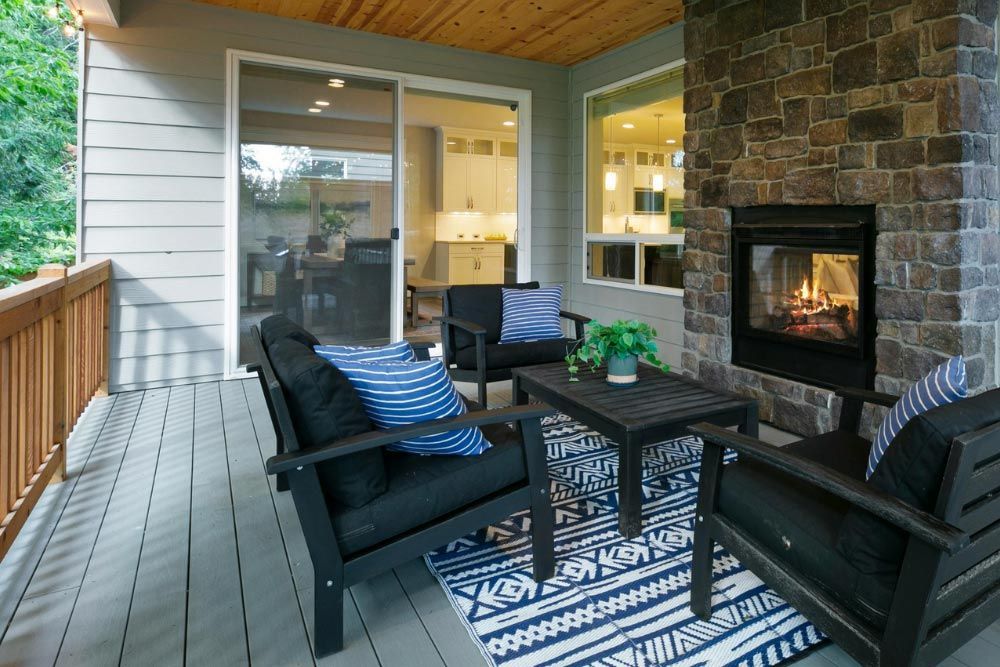 A patio with a fireplace and chairs on it