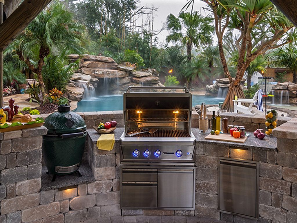 An outdoor kitchen with a grill and a green egg