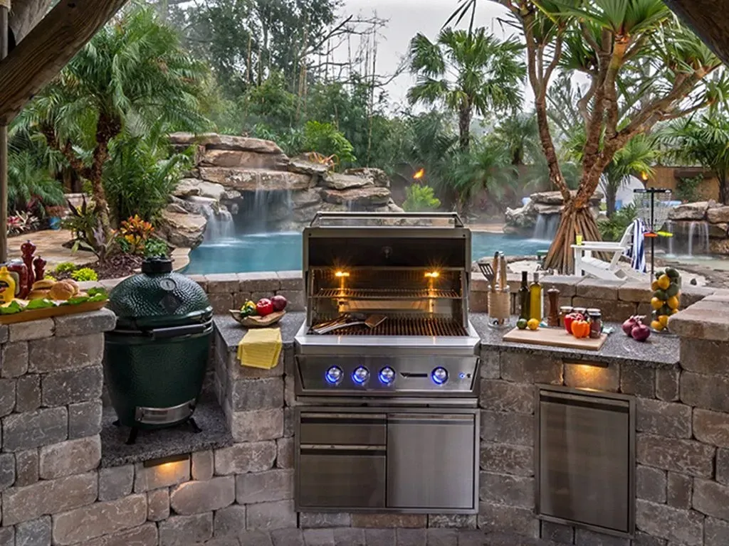 An outdoor kitchen with a grill and a green egg