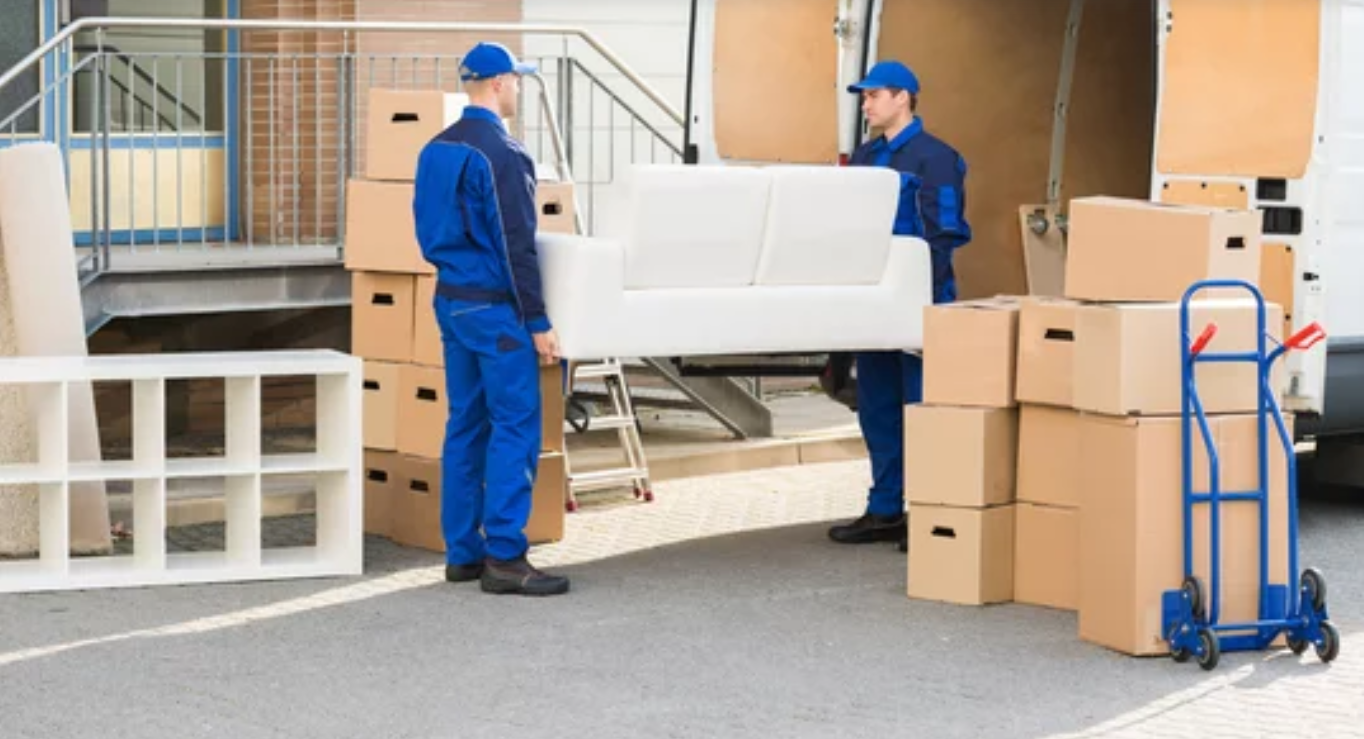 Movers carefully transporting a sofa from a truck onto the street.