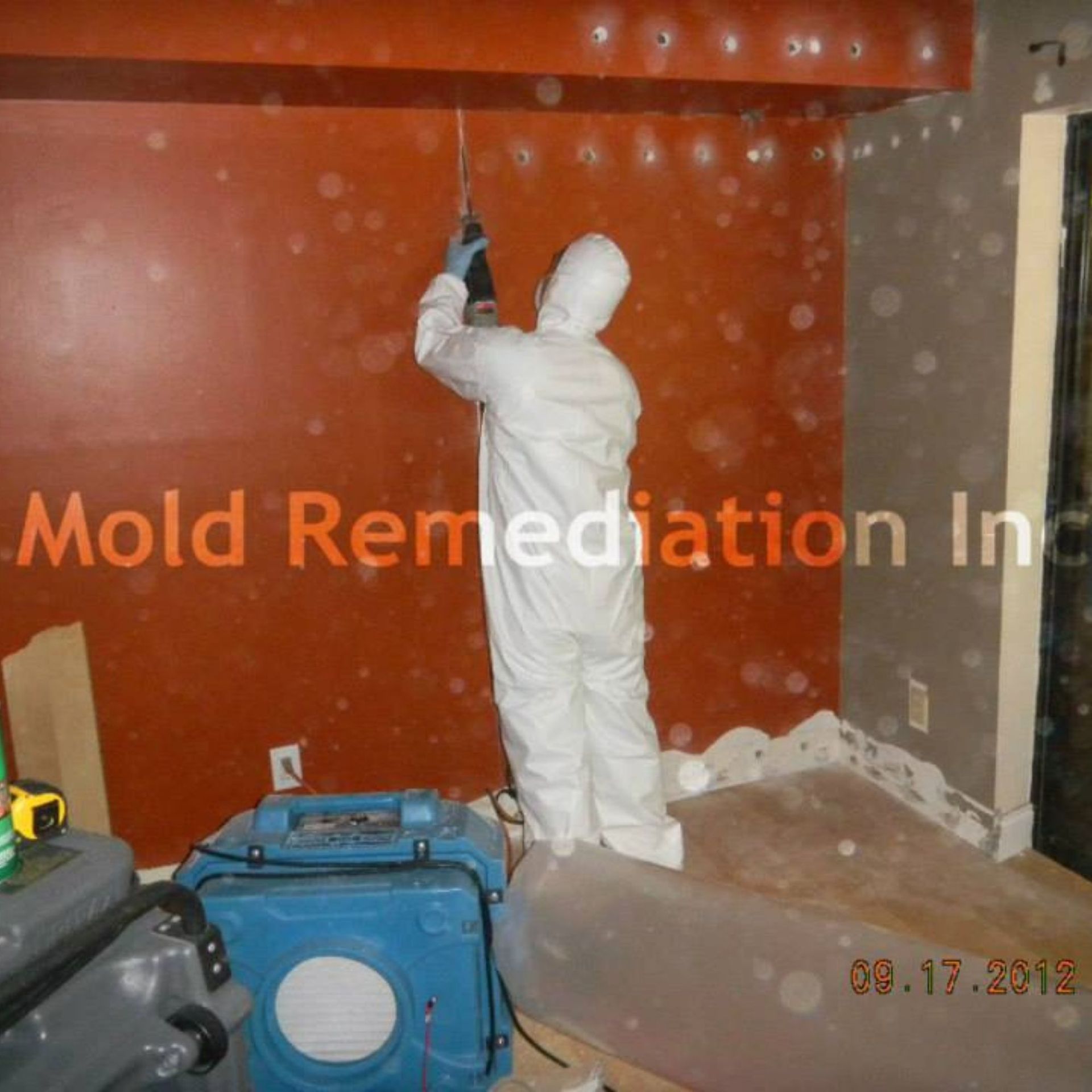 Mold Remediation Inc -A man in a white suit is working in a room with the words mold remediation in the corner