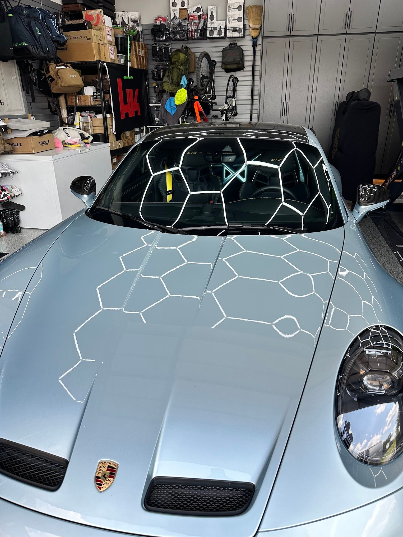 A silver porsche 911 is parked in a garage.