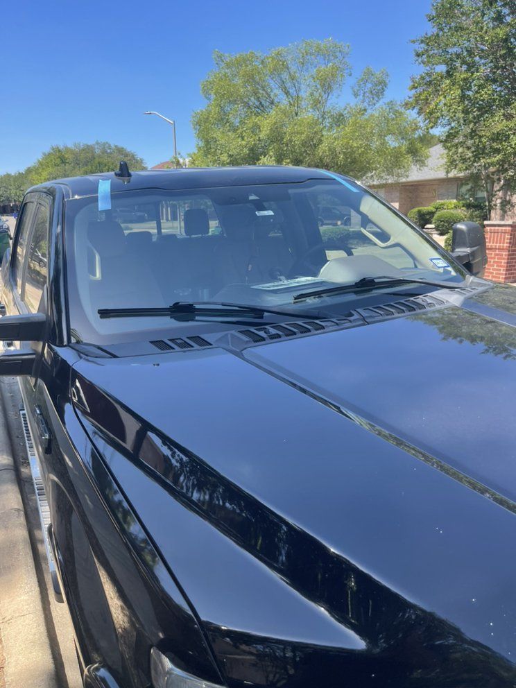 A black truck is parked on the side of the road