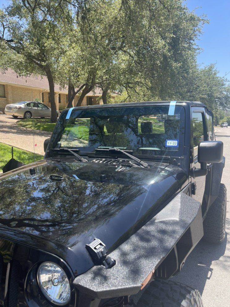 A black jeep is parked on the side of the road.