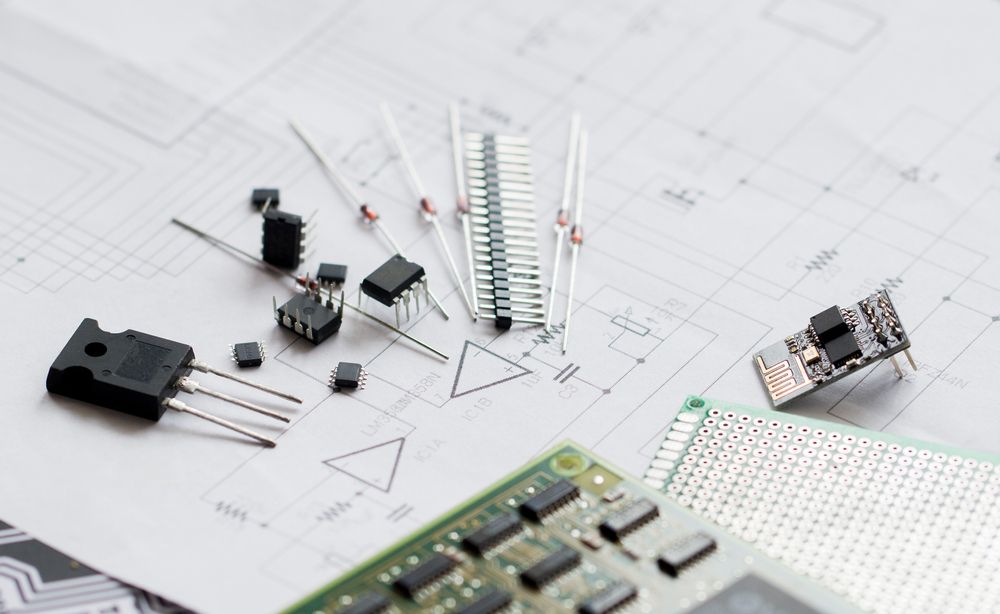 Electronic components scattered on a circuit diagram, including transistors, resistors, and circuit boards.