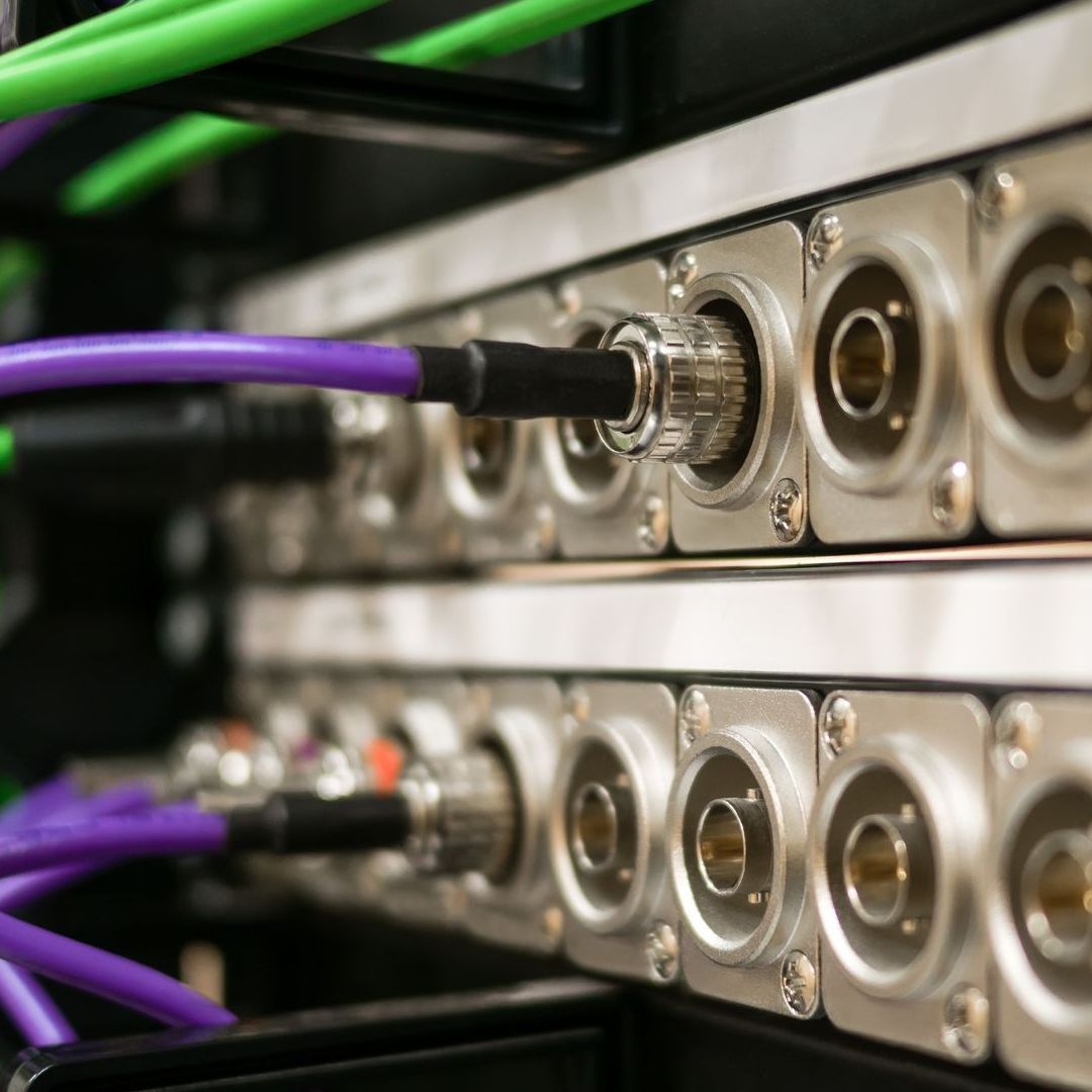 A bunch of wires are connected to a server in a server room.