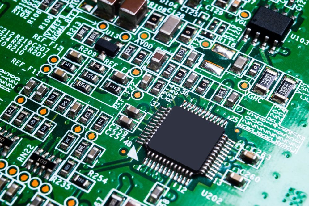 Green circuit board with various electronic components.