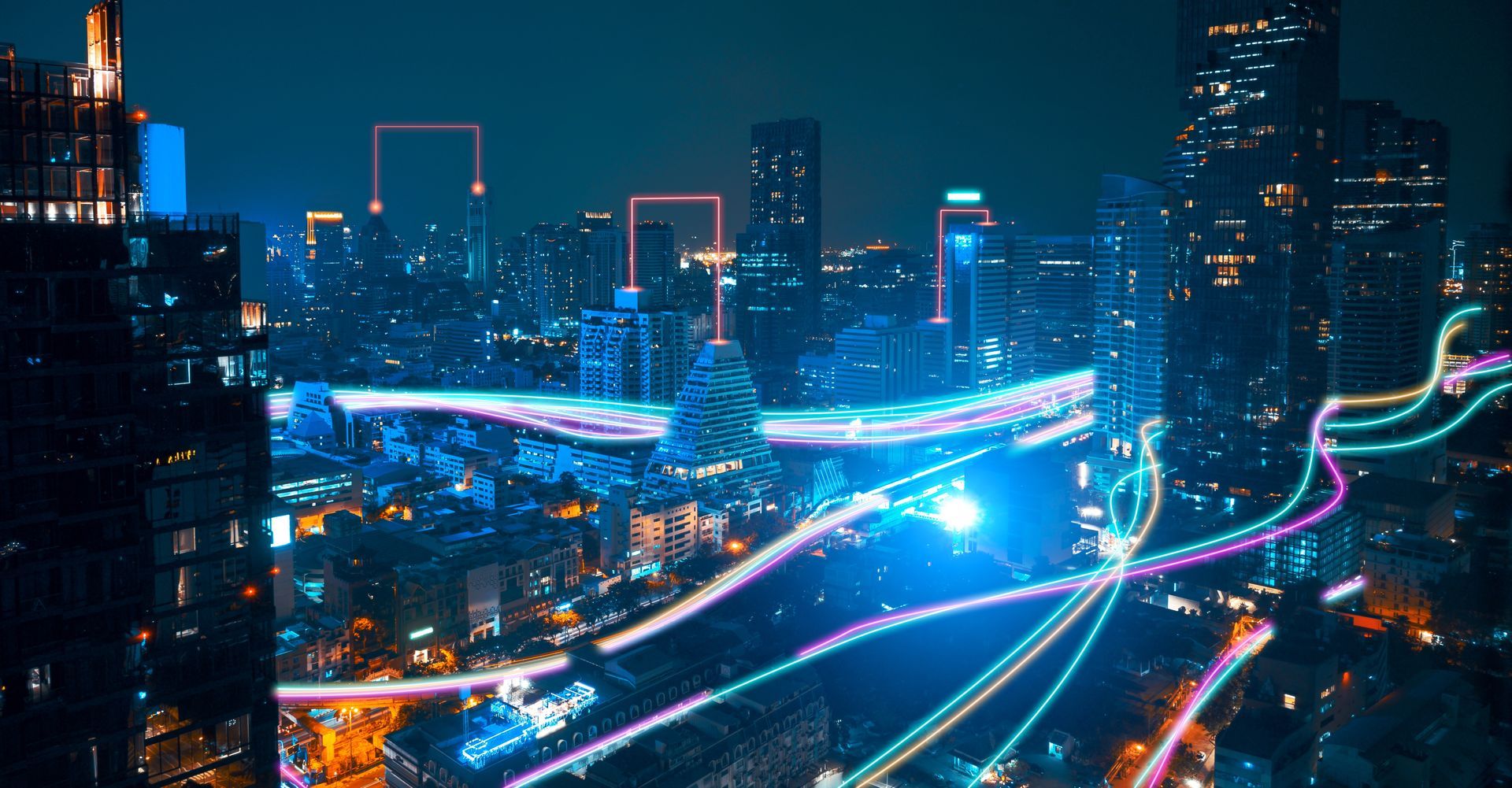 An aerial view of a city at night with neon lights.