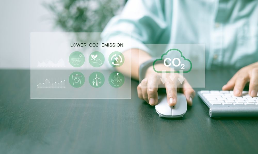 Person using computer with a virtual display showing green initiatives and a CO2 symbol.