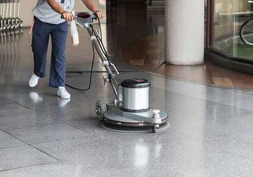 Worker cleaning the floor with polishing machine Worker cleaning the floor with polishing machine