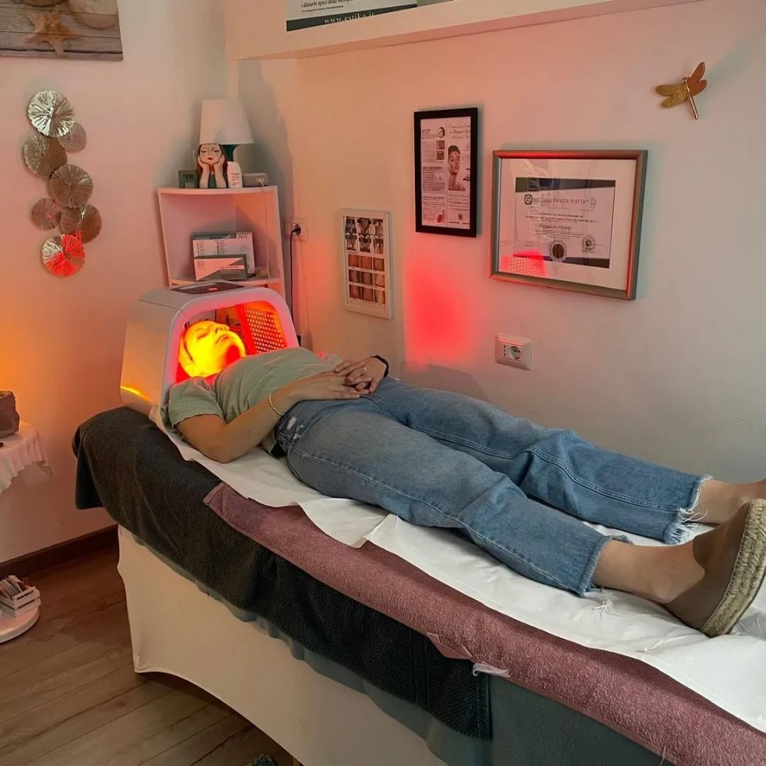 Persona sottoposta a terapia con luce rossa in una spa. Sdraiata su un lettino con una luce sul viso.