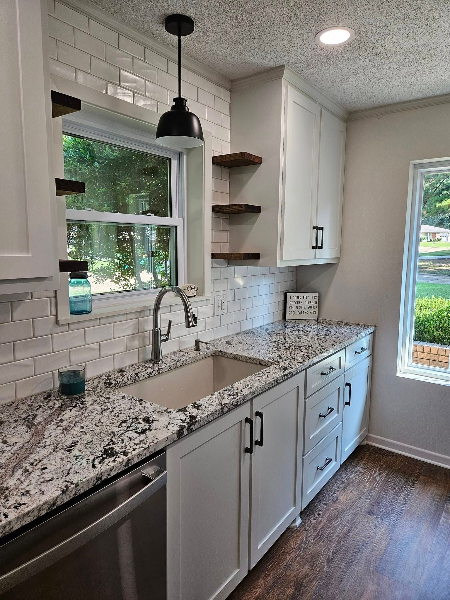 Woman in straw hat smiles, holding wine glass near a lake.