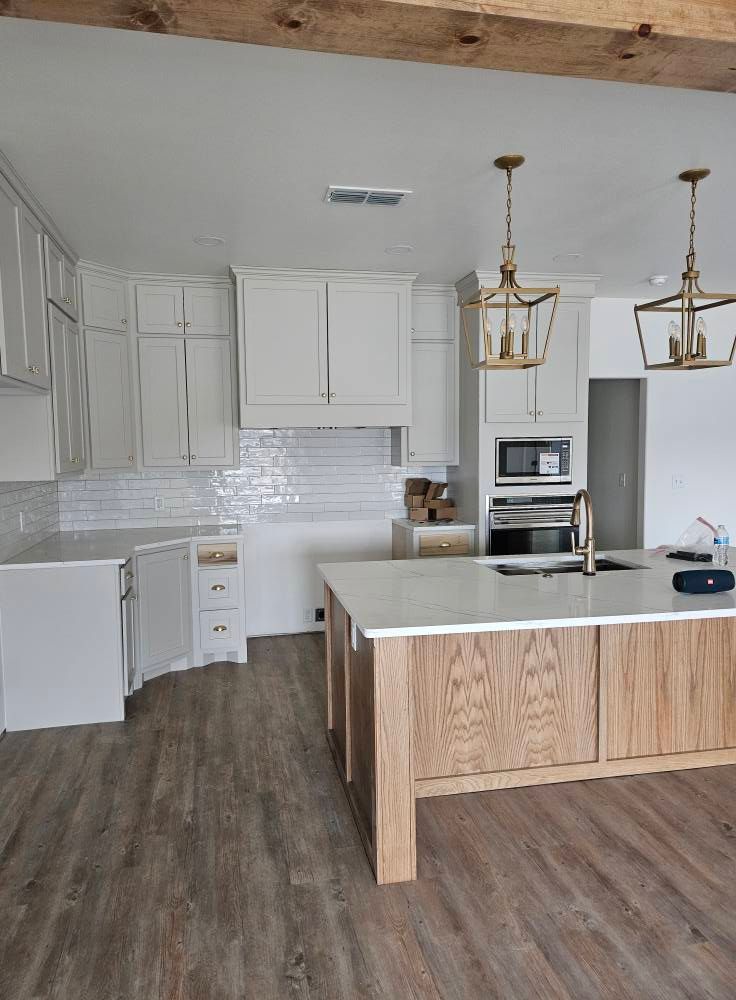 Woman in straw hat smiles, holding wine glass near a lake.