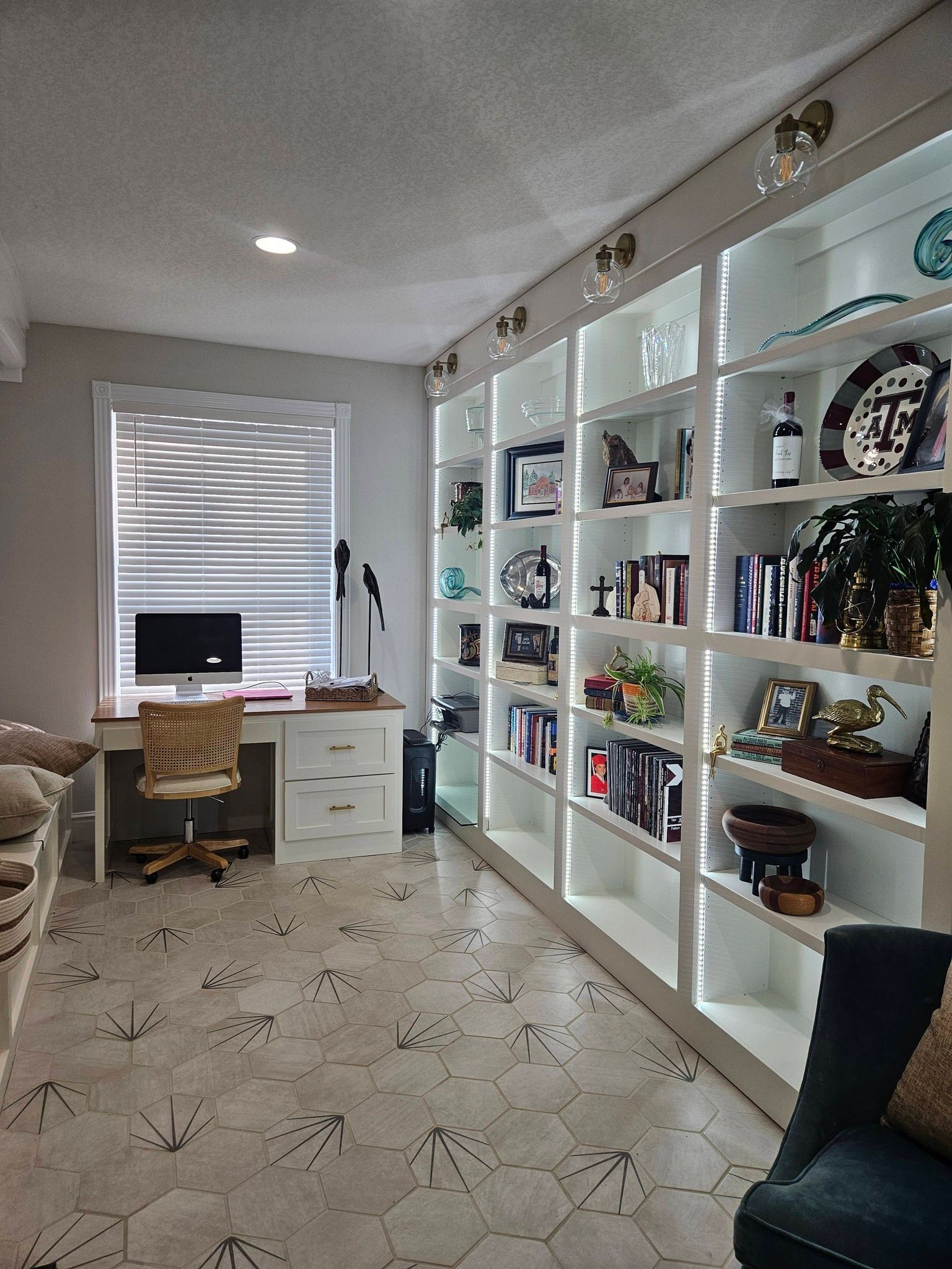 Woman in straw hat smiles, holding wine glass near a lake.