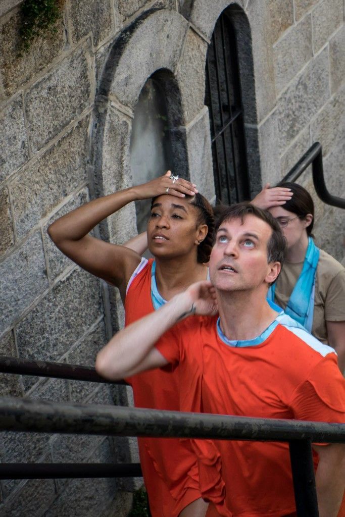 A group of people are standing next to each other in front of a brick building.