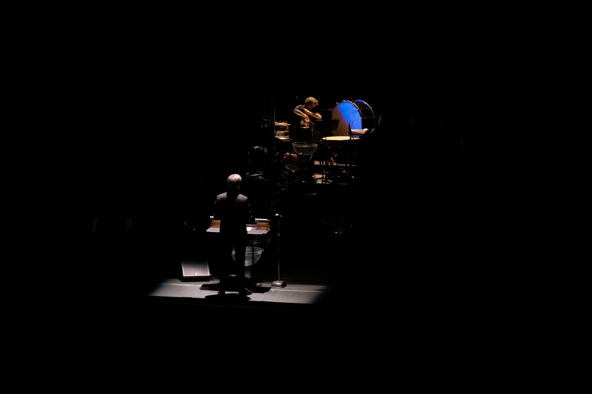 A group of people are standing on a stage in the dark.